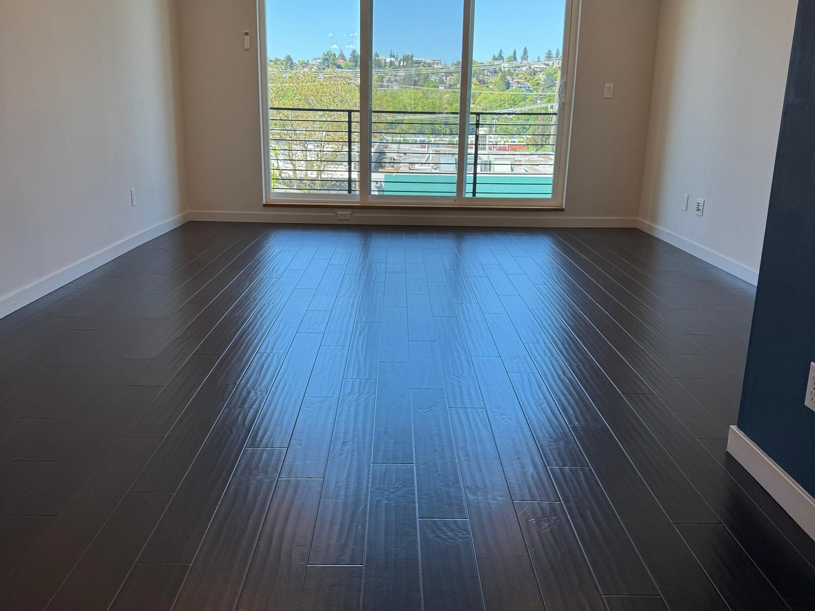 Bright living room with gleaming dark hardwood floors after a full clean